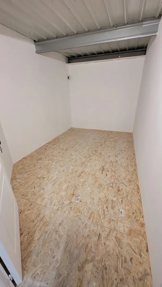 Box de stockage à l'étage, murs blancs et plancher en bois