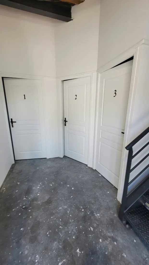Couloir du rez-de-chaussée avec les portes numérotées des box de stockage